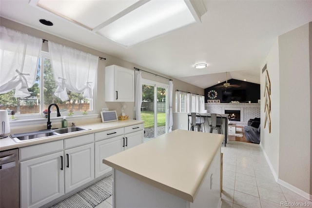 5552 S Lisbon Ln, Centennial, CO 80015 - kitchen featuring light tile patterned floors, dishwasher, white cabinets, open floor plan, and a center island