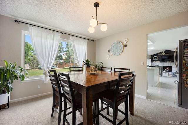 5552 S Lisbon Ln, Centennial, CO 80015 - dining space with light colored carpet, a textured ceiling, a chandelier, and a warm lit fireplace