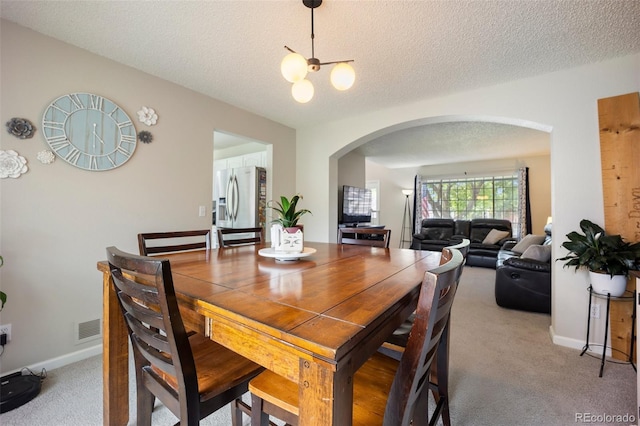 5552 S Lisbon Ln, Centennial, CO 80015 - dining room with arched walkways, light carpet, a textured ceiling, and a chandelier