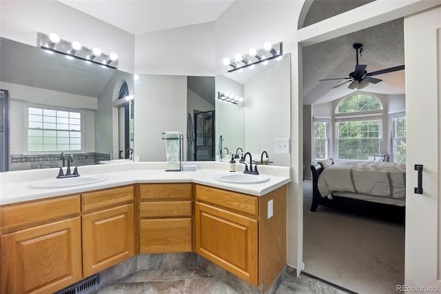 5552 S Lisbon Ln, Centennial, CO 80015 - ensuite bathroom with lofted ceiling, double vanity, ceiling fan, and a shower with door