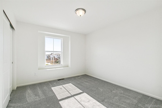 spare room with dark colored carpet