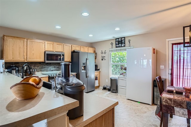 17390 Waterhouse Cir Unit B, Parker, CO 80134 - kitchen featuring appliances with stainless steel finishes, light brown cabinetry, decorative backsplash, recessed lighting, and light countertops