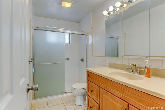 bathroom featuring tile patterned floors, toilet, a shower with door, and vanity