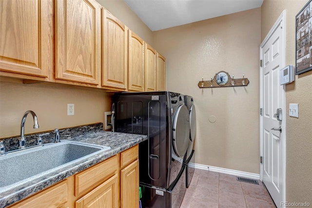 clothes washing area with sink, light tile patterned floors, cabinets, and independent washer and dryer