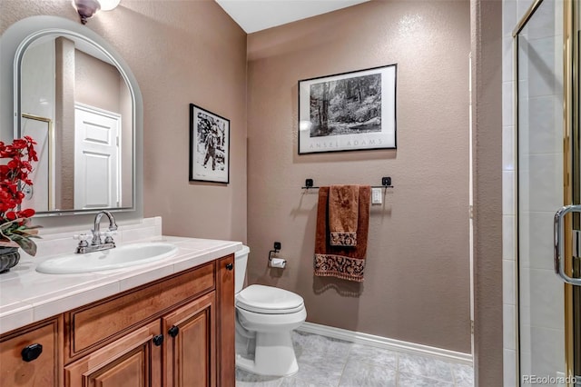 bathroom with vanity, toilet, and a shower with shower door