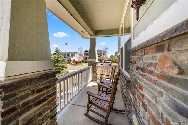 balcony featuring covered porch and a residential view