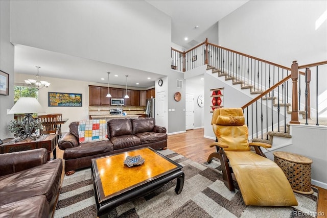 living room featuring stairway, baseboards, light wood-type flooring, and recessed lighting