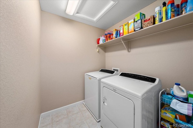 clothes washing area with laundry area, baseboards, and separate washer and dryer