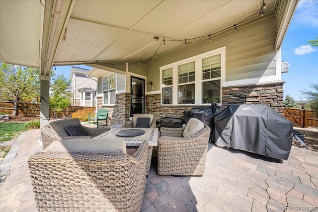view of patio with grilling area, fence, and outdoor lounge area