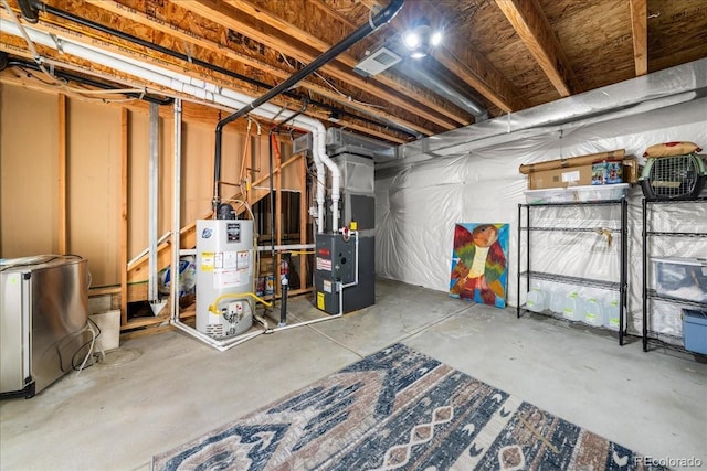 unfinished basement featuring visible vents, refrigerator, heating unit, and gas water heater