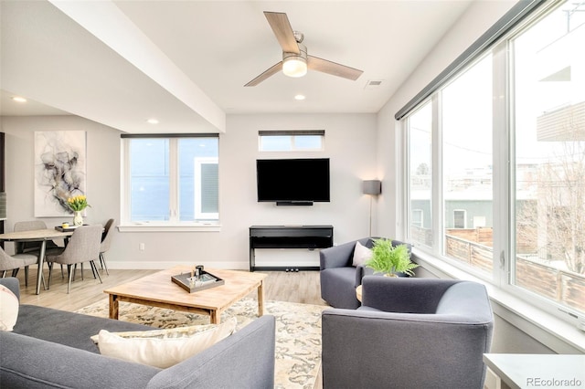 living area featuring a ceiling fan, light wood-type flooring, visible vents, baseboards, and recessed lighting
