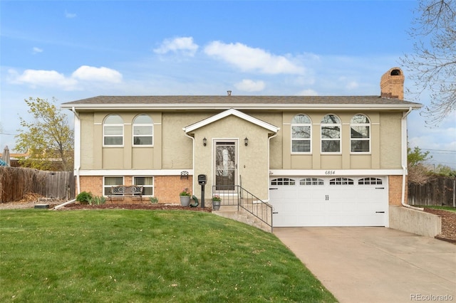 6854 S Willow St, Centennial, CO 80112 - raised ranch with driveway, a chimney, fence, a front lawn, and an attached garage