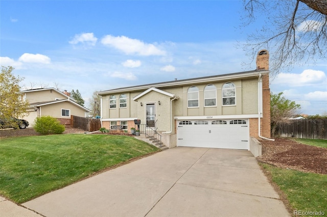 6854 S Willow St, Centennial, CO 80112 - split foyer home featuring driveway, a chimney, a garage, fence, and a front lawn