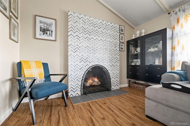 6854 S Willow St, Centennial, CO 80112 - interior space with a tiled fireplace, baseboards, vaulted ceiling, and wood finished floors
