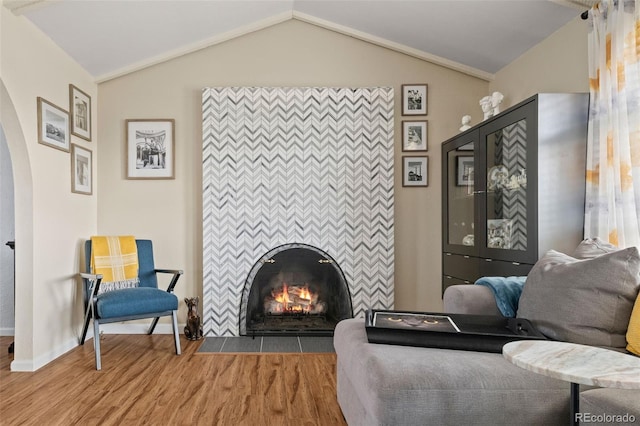 6854 S Willow St, Centennial, CO 80112 - living area with arched walkways, vaulted ceiling, wood finished floors, a tile fireplace, and baseboards