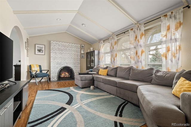 6854 S Willow St, Centennial, CO 80112 - living room with arched walkways, vaulted ceiling, wood finished floors, and a fireplace