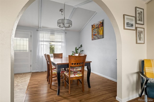 6854 S Willow St, Centennial, CO 80112 - dining room with arched walkways, wood finished floors, baseboards, lofted ceiling, and a textured wall