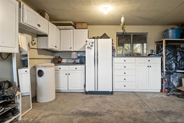 6854 S Willow St, Centennial, CO 80112 - kitchen featuring dark countertops, freestanding refrigerator, concrete flooring, and white cabinetry