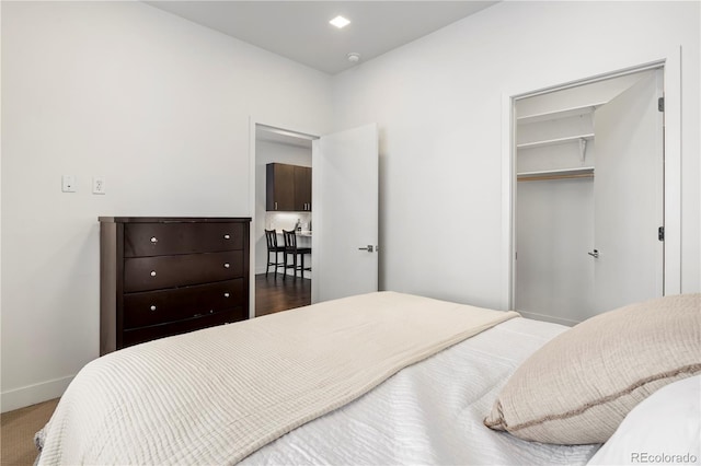 bedroom featuring a spacious closet and baseboards
