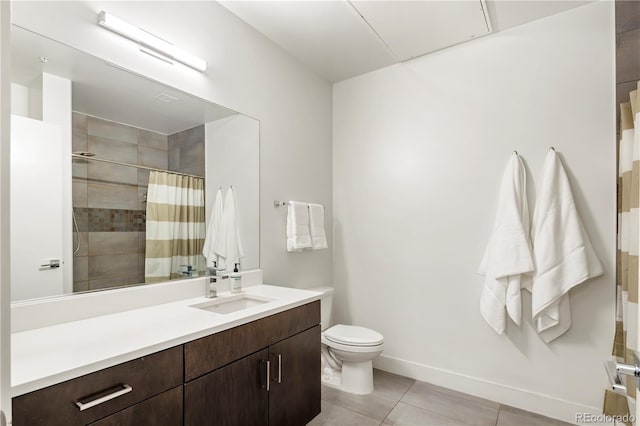 bathroom with tile patterned floors, toilet, a tile shower, baseboards, and vanity