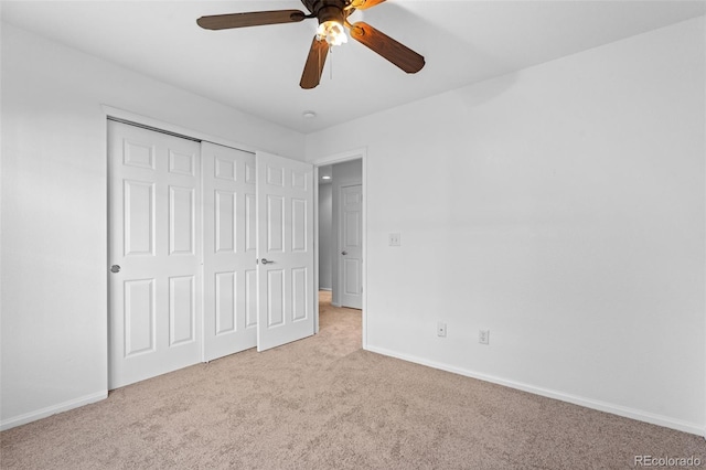 unfurnished bedroom featuring light colored carpet, ceiling fan, and a closet