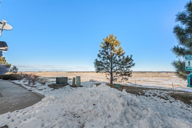 snowy yard featuring a rural view