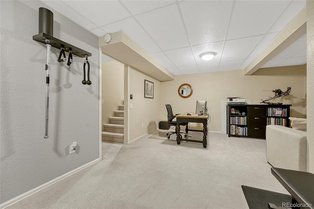 carpeted home office with a drop ceiling