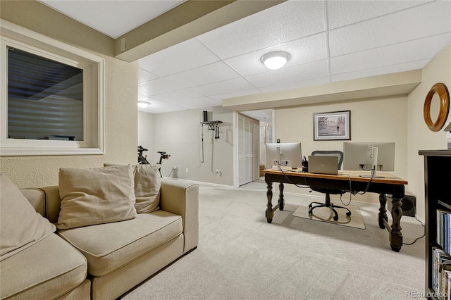 carpeted office space featuring a paneled ceiling