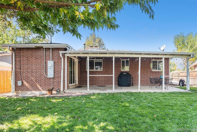 rear view of property with a yard and a patio