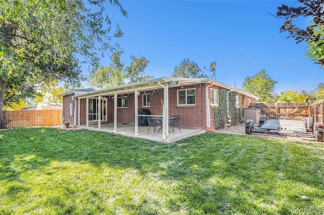 back of house featuring a patio and a yard