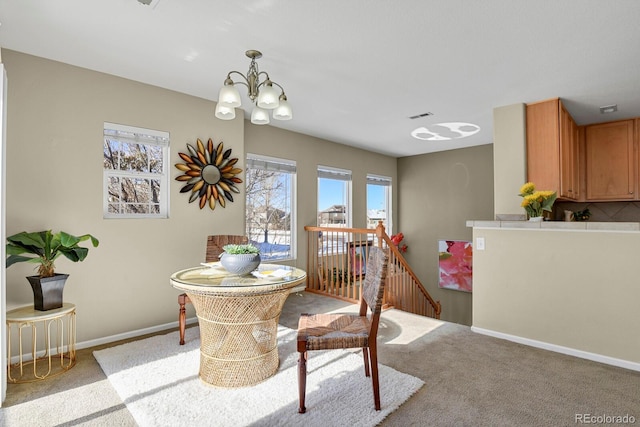 dining room featuring light carpet and a chandelier