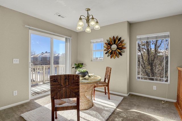 carpeted dining space with a chandelier