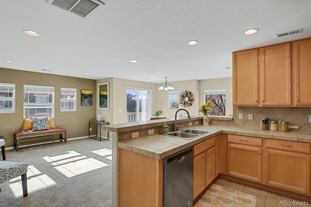 kitchen with tile counters, sink, stainless steel dishwasher, a notable chandelier, and kitchen peninsula