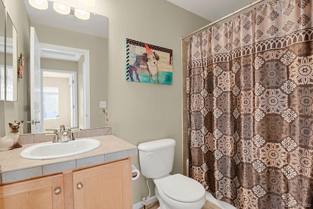 bathroom featuring a shower with curtain, vanity, and toilet