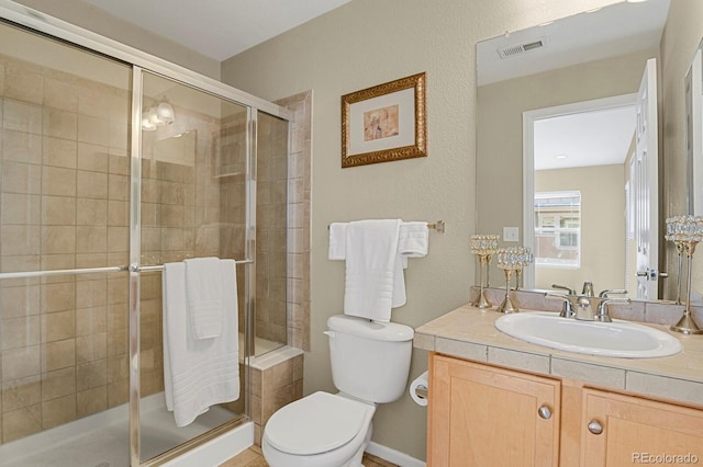 bathroom with vanity, toilet, and an enclosed shower