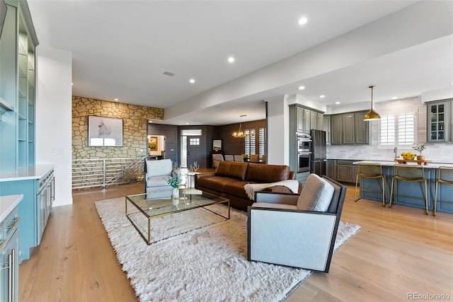 living room with a notable chandelier, recessed lighting, and light wood finished floors