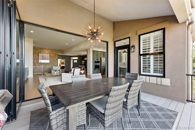 dining area featuring recessed lighting, lofted ceiling, an inviting chandelier, and wood finished floors