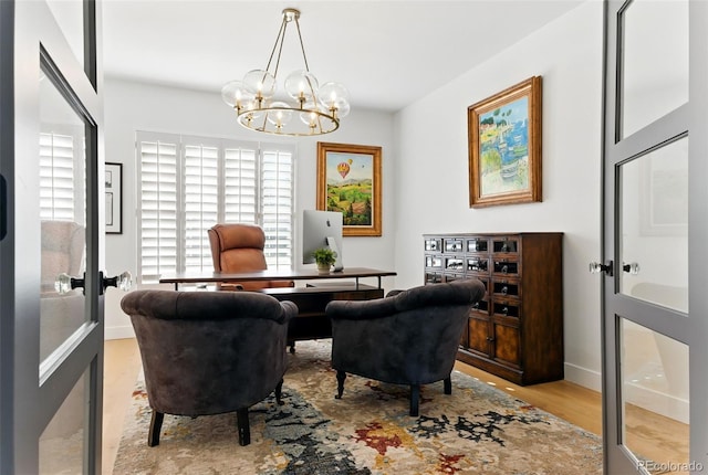 home office with a chandelier and wood finished floors