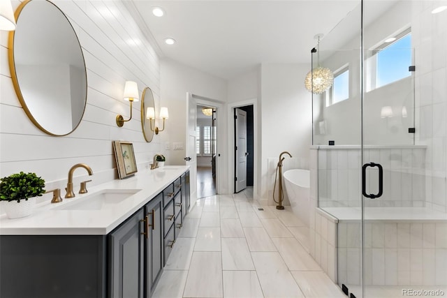 full bathroom with a stall shower, a sink, recessed lighting, double vanity, and a freestanding bath