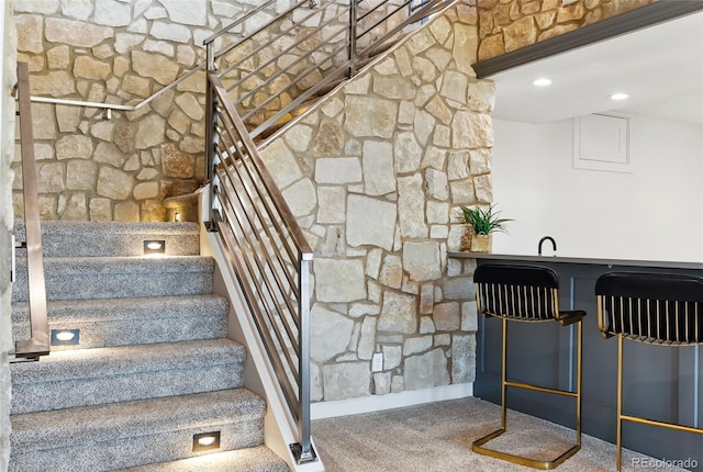 stairway featuring indoor wet bar, carpet flooring, and recessed lighting