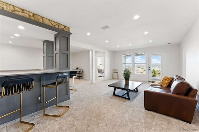 living area with recessed lighting, visible vents, baseboards, and light colored carpet