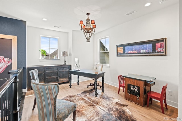 office area with light hardwood / wood-style floors and a notable chandelier