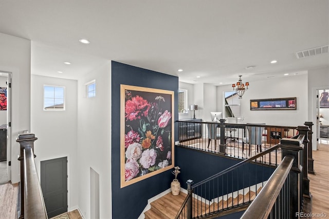 corridor featuring hardwood / wood-style flooring and an inviting chandelier