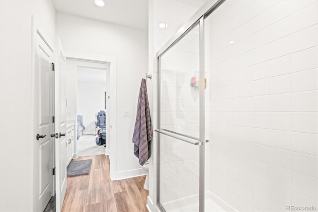 bathroom with toilet, hardwood / wood-style flooring, and walk in shower