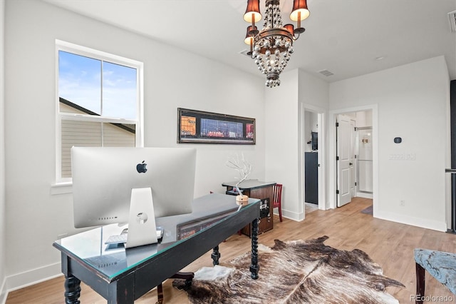 office space with a notable chandelier and light hardwood / wood-style floors