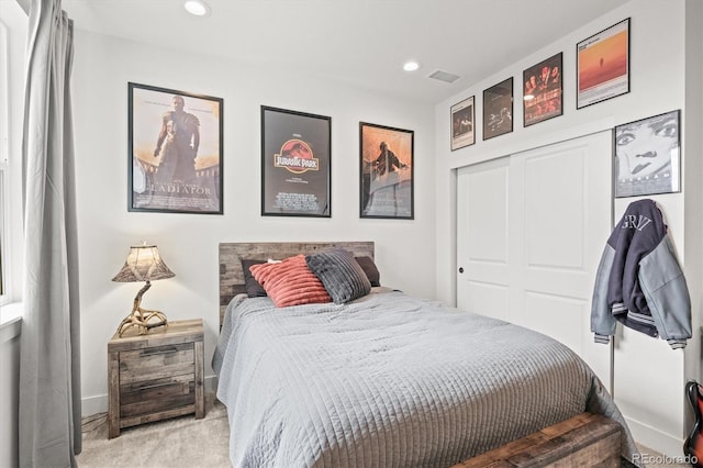 bedroom featuring light colored carpet and a closet