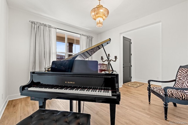 miscellaneous room featuring hardwood / wood-style floors and an inviting chandelier