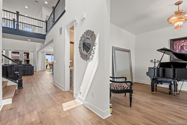 entryway featuring a high ceiling, an inviting chandelier, and hardwood / wood-style floors