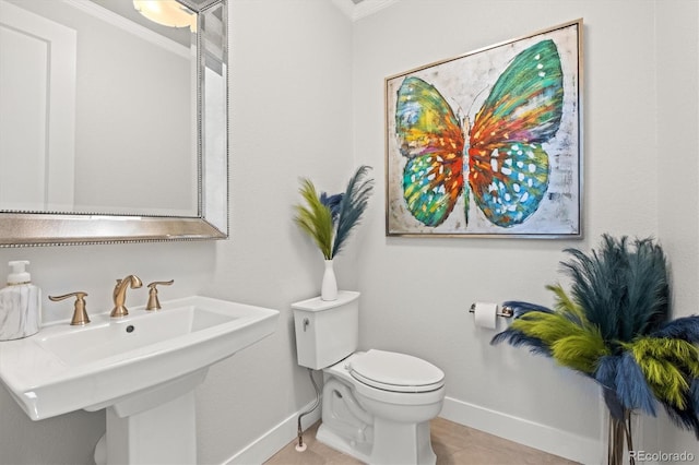 bathroom with ornamental molding, sink, toilet, and tile patterned floors