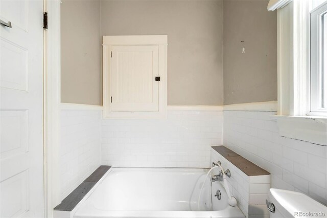 130 S Humboldt St, Denver, CO 80209 - bathroom featuring toilet, a bath, tile walls, and wainscoting